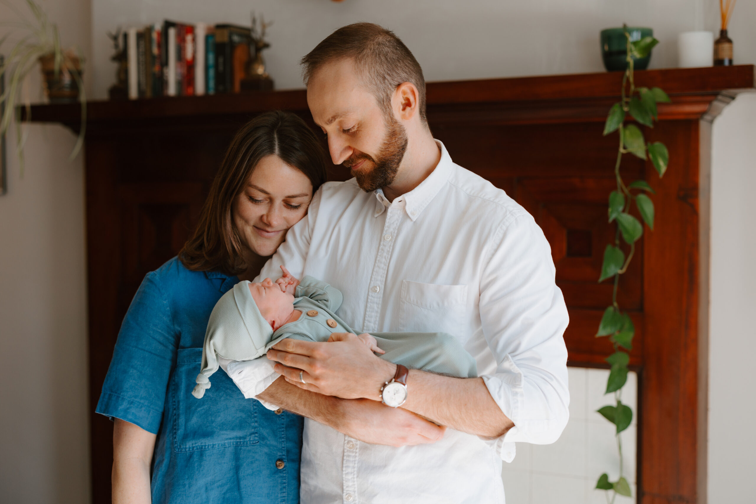Couple looking at newborn baby during family photos