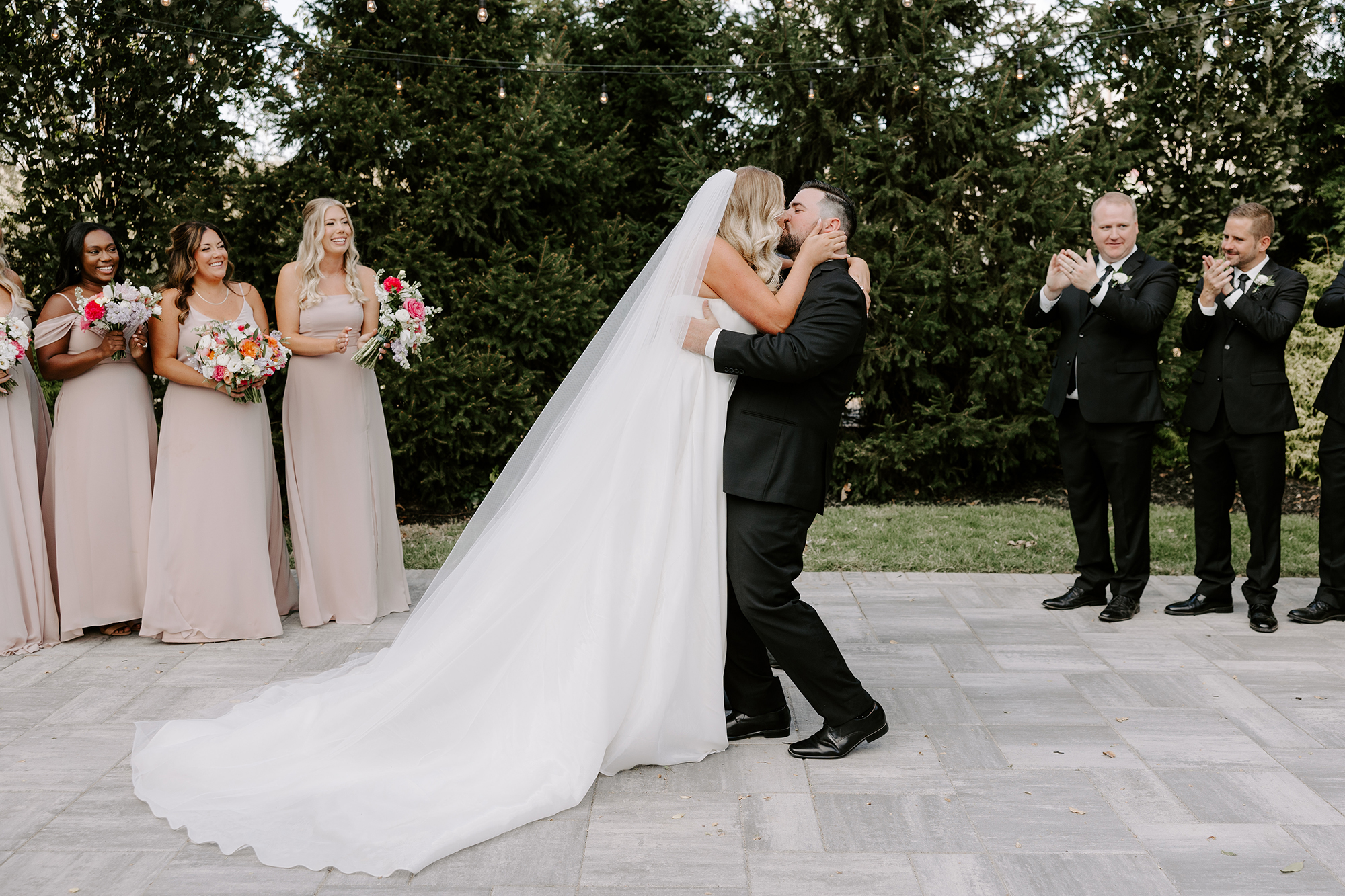 Bride and groom kiss during outdoor ceremony at Wild Carrot in St. Louis, Missouri