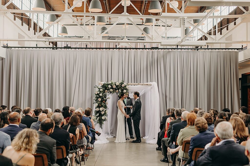 A bride and groom during their ceremony at at The Hall at Olive and Oak in Webster Groves, Missouri.