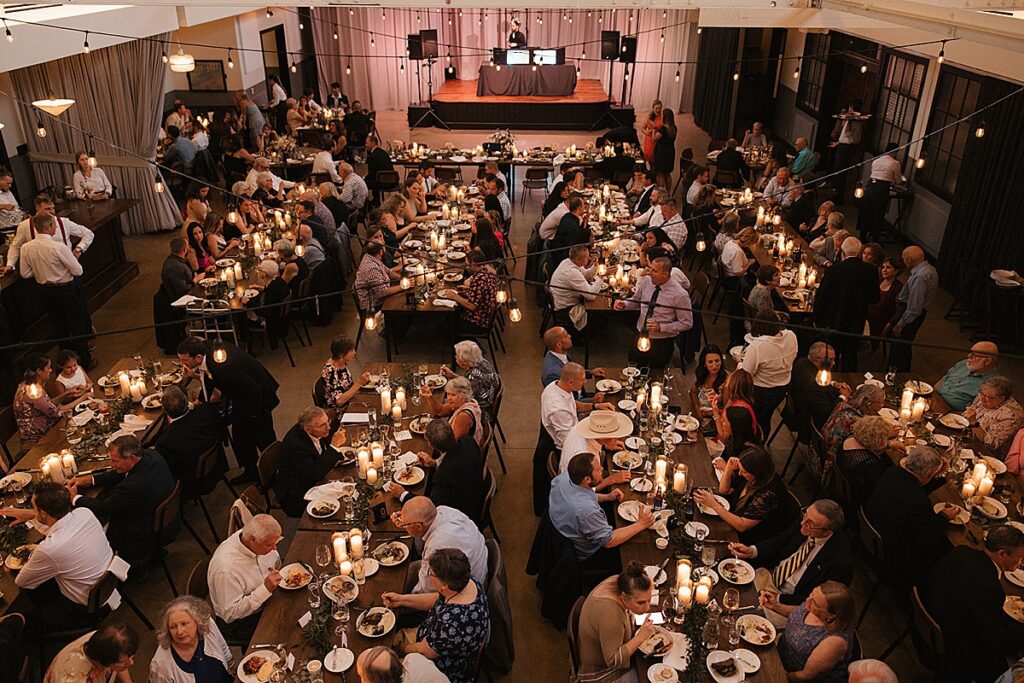 An aerial view of a wedding reception with people eating at at The Hall at Olive and Oak in Webster Groves, Missouri.