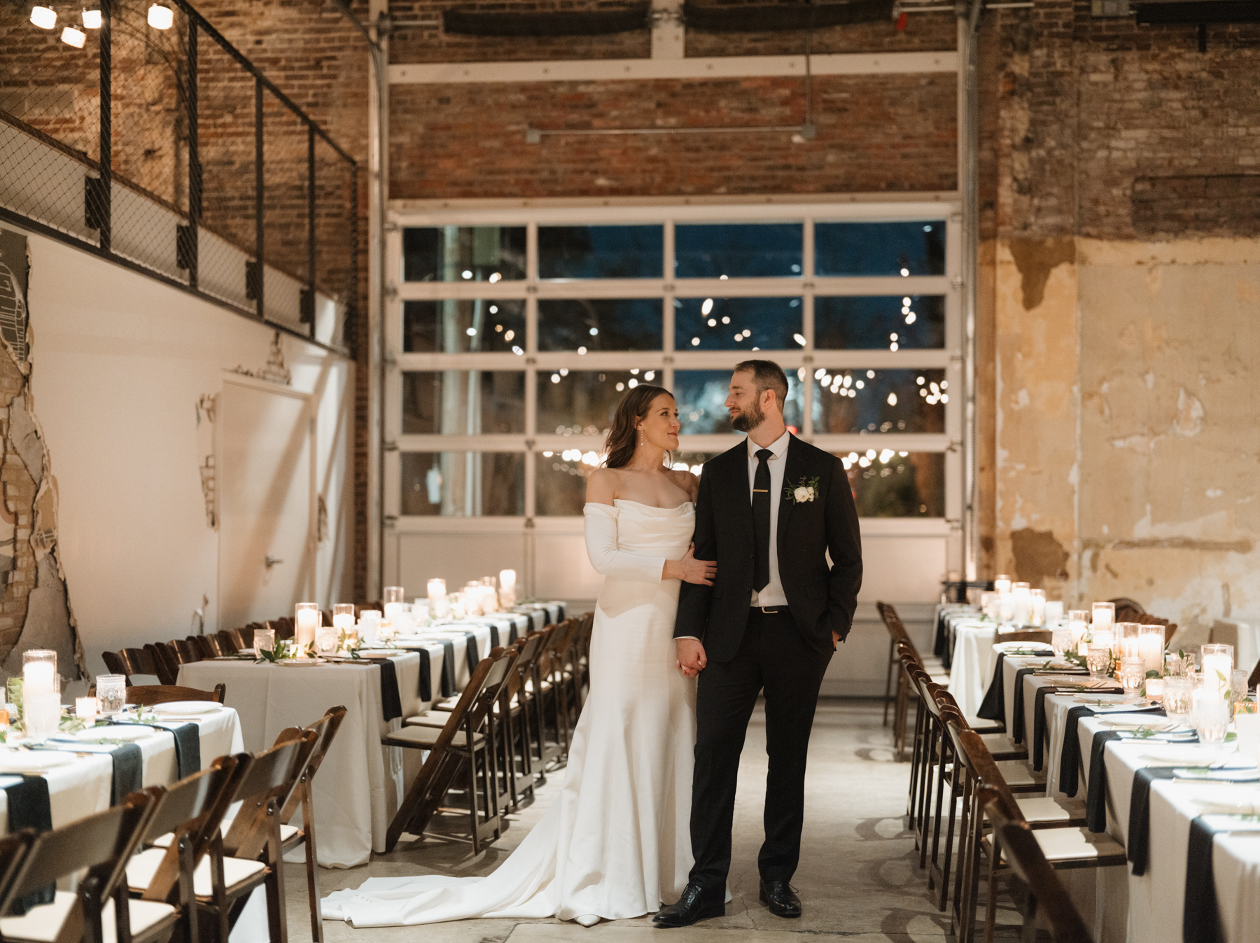 A bride and groom look at one another in the middle of their reception space, located at Wild Carrot in St. Louis, Missouri.