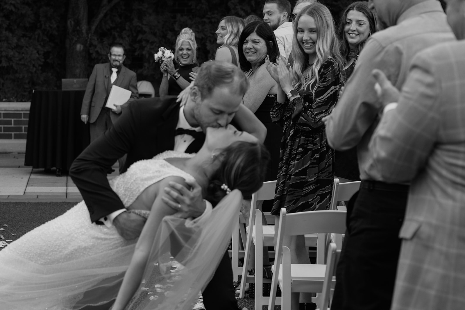 Black and white image of bride and groom kissing in aisle during their Ameristar Casino wedding ceremony