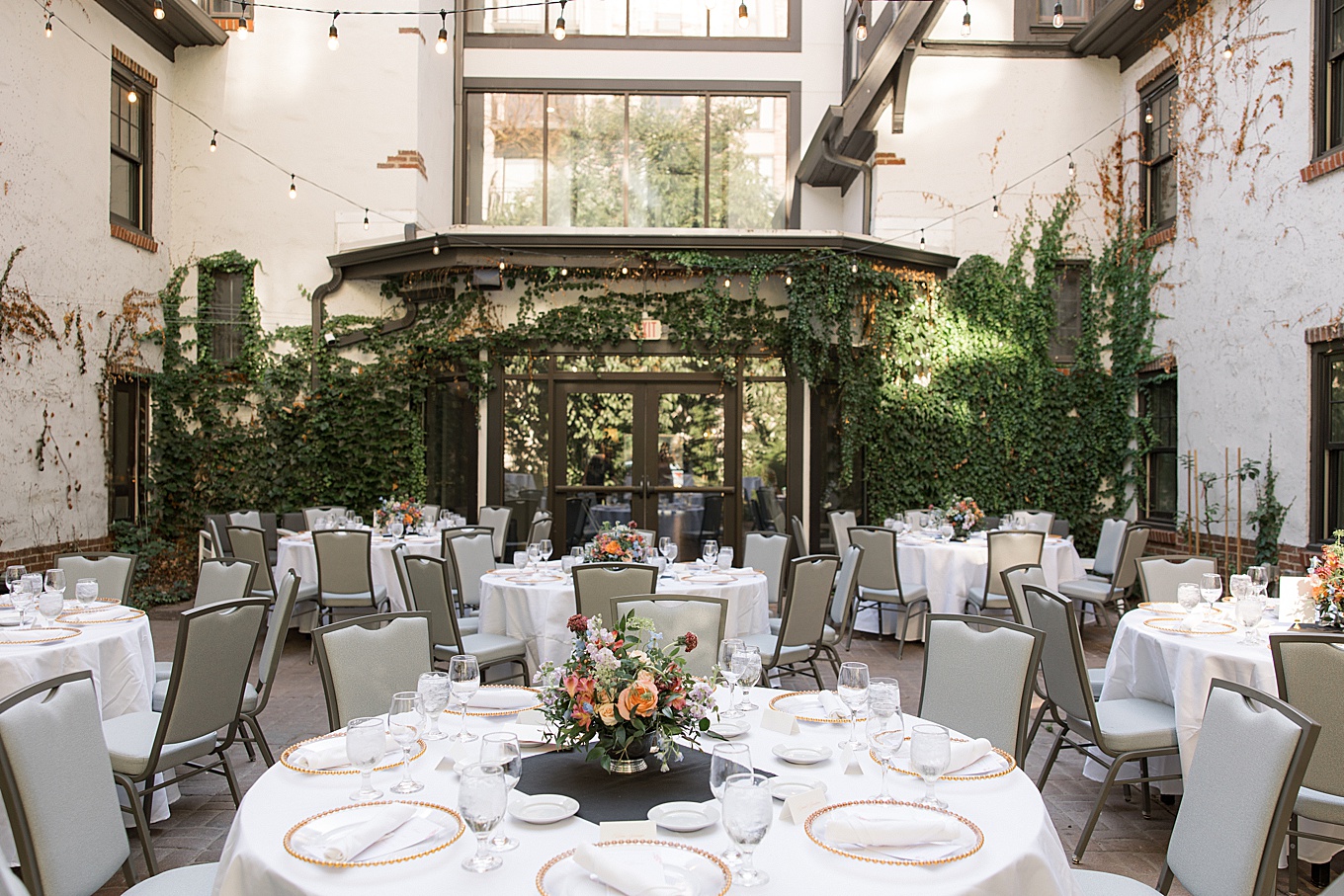 Tables with florals in the courtyard of the Seven Gables Inn hotel in Clayton, Missouri