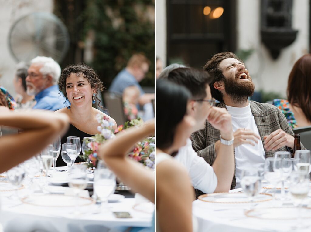 Two guests laughing while sitting at a table during a rehearsal dinner at Seven Gables Inn in Clayton, Missouri.