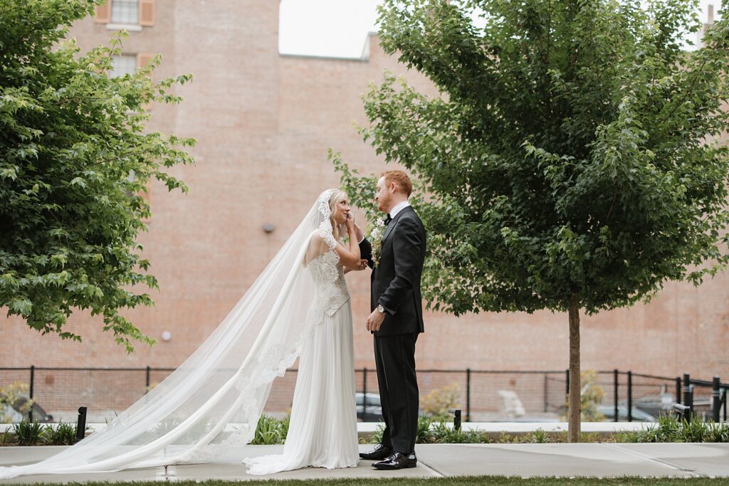 Bride and groom sharing first look with emotional exchange outside of the 21C Hotel in St. Louis, Missouri